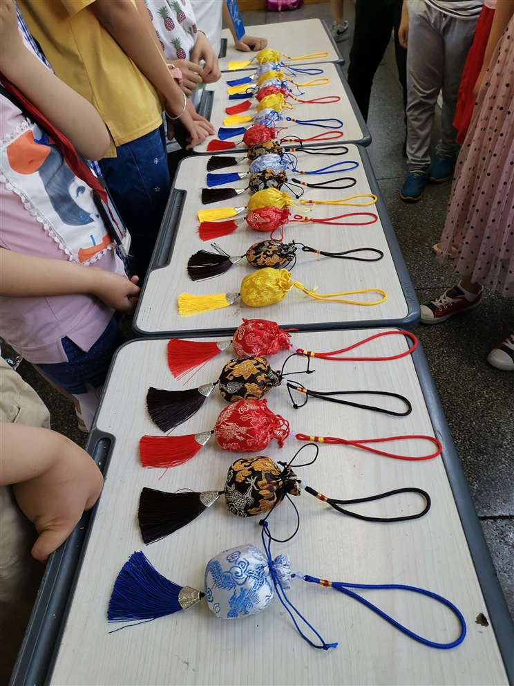 6月5日，中天精誠裝飾集團(tuán)的志愿者們在總經(jīng)理助理施江鋒的帶領(lǐng)下來到嵊州市下王鎮(zhèn)中心小學(xué)，為鄉(xiāng)村小學(xué)的孩子們帶去精彩的職業(yè)體驗(yàn)項(xiàng)目、端午禮物及溫暖的陪伴。  此次DO益行為孩子們帶來了飲品研發(fā)師、禁毒警察、美發(fā)設(shè)計(jì)師、魔術(shù)師、時(shí)裝設(shè)計(jì)師、郵遞員、印染師、百貨員的體驗(yàn)項(xiàng)目。活動現(xiàn)場，兩個(gè)多小時(shí)的體驗(yàn)，排隊(duì)等候、好奇、嘗試、探索與實(shí)踐，打破了志愿者與孩子們之間的陌生感，也圓了孩子們的職業(yè)夢。   臨近端午節(jié)，中天精誠裝飾的志愿者們還帶來了一項(xiàng)特色傳統(tǒng)文化活動——制作端午香囊， 佩香囊，是端午傳統(tǒng)習(xí)俗之一，香囊內(nèi)通常填充一些具有芳香開竅的中草藥，有清香、驅(qū)蟲、避瘟、防病等功能。這份“體驗(yàn)感十足”的端午節(jié)禮物贏得學(xué)生們的喜愛，在體驗(yàn)課上，學(xué)生們了解端午節(jié)的由來和習(xí)俗并親手制作端午香囊，把關(guān)心裝入香囊送給家人。  “人人可慈善、人人應(yīng)慈善”，付出、愛、公益、夢想，這些關(guān)鍵詞串起了志愿者與鄉(xiāng)村孩子的心，我們會一起努力，在成長的路上學(xué)會勇敢面對各種挑戰(zhàn)，最終實(shí)現(xiàn)自己的夢想。